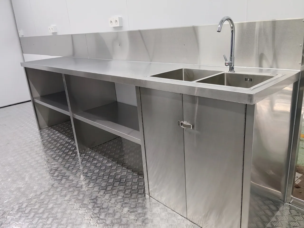 Double évier en inox et rangements ouverts sous le plan de travail
