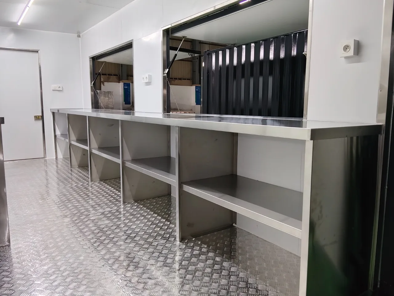 Intérieur du conteneur snack : comptoirs en inox et baies de service ouvertes