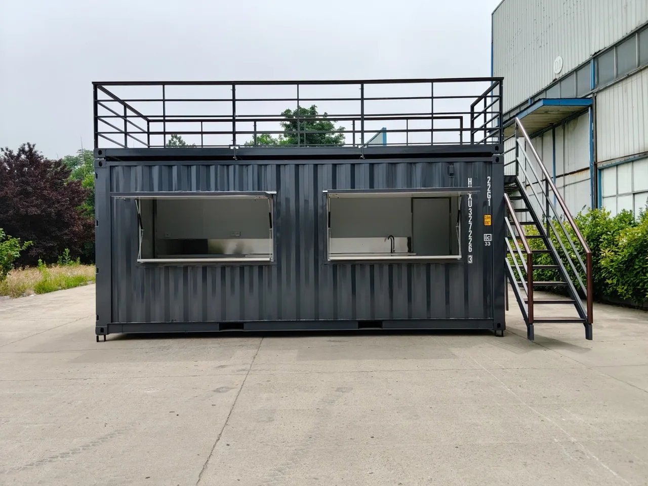 Conteneur snack rooftop vu de face, baies de service ouvertes et terrasse sur le toit